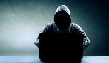 Hacker with hoodie on black laptop
