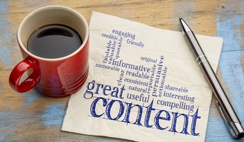 Wrting great content written on napkin next to red coffee cup